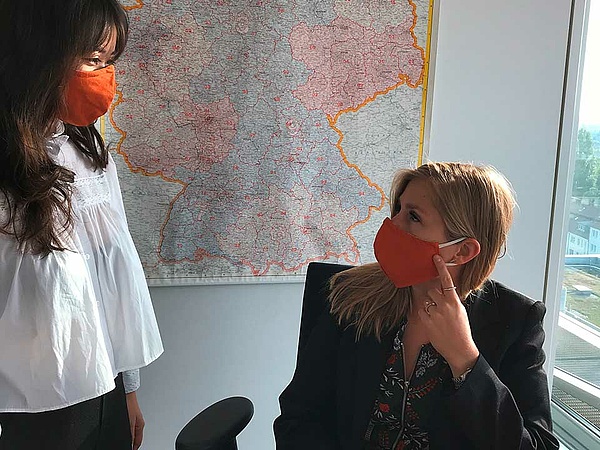 zwei Fachkräfte im Büro tragen eine Mund-Nasen-Maske